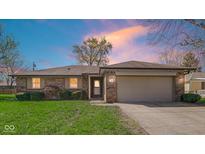 Charming single-story brick home featuring a two-car garage and well-maintained front lawn at 715 Pioneer Dr, Indianapolis, IN 46217