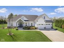 Charming home with a manicured lawn, an attached three-car garage and a welcoming front porch at 978 S Fairway Village Ct, Greenfield, IN 46140