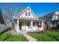 Charming two-story home featuring a gabled roof, inviting front porch and well-manicured lawn under a clear blue sky at 106 N Linwood Ave, Indianapolis, IN 46201