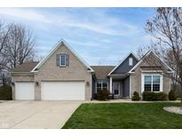 Charming brick home featuring a two-car garage, manicured lawn, and classic architectural details under a beautiful sky at 2890 Trillium Way, Columbus, IN 47201