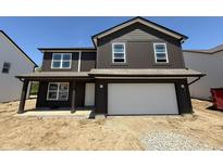 Charming two-story home featuring a two-car garage, covered entry, and dark siding at 3309 Godby Dr, Sheridan, IN 46069