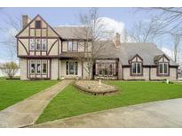 Charming Tudor-style home with a well-manicured lawn and decorative fountain at 3892 Arrowhead Ct, Greenfield, IN 46140