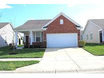 Charming single-Gathering home featuring a well-manicured lawn and attached two-car garage at 5069 Lilium Dr, Plainfield, IN 46168