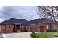 Stately brick home featuring a large driveway and a three-car garage, with a covered front entryway at 5373 Ashby Ct, Greenwood, IN 46143