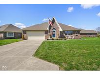 Charming brick home with a well-manicured lawn, American flag, and inviting curb appeal at 5766 Kensington S Way, Plainfield, IN 46168