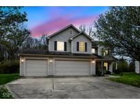 Two-story home with three-car garage, siding, and black shutters against a beautiful colorful sky at 5856 Long Ridge Pl, Indianapolis, IN 46221
