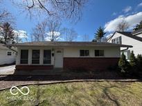 Charming single-story home with a brick facade and well-maintained landscaping at 5868 Hillside Ave, Indianapolis, IN 46220