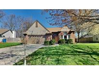 Charming brick home with a well-manicured lawn and attached two-car garage, nestled in a lovely neighborhood at 6508 Pergola Ln, Indianapolis, IN 46241