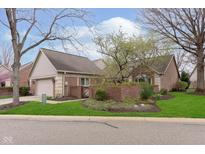 A brick home with an attached garage, a brick wall, and a well-manicured lawn at 8535 Olde Mill Circle West Dr, Indianapolis, IN 46260
