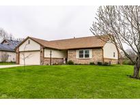 Charming brick and vinyl home featuring a well-manicured lawn and attached two car garage at 8973 Sunningdale Blvd, Indianapolis, IN 46234