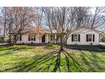 Charming brick ranch home with a well-maintained lawn and inviting front porch with rocking chairs at 9303 Nora Ln, Indianapolis, IN 46240
