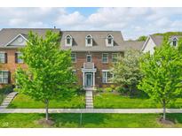 Charming brick townhouse with a well-manicured lawn and inviting front entrance with balcony at 13510 E 131St St, Fishers, IN 46037
