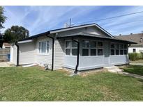 Charming single-story home featuring vinyl siding, a well-maintained lawn and a covered porch with ample windows at 1546 Kappes St, Indianapolis, IN 46221