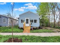 Charming single-Gathering home featuring a new wood porch and light-blue siding, landscaped yard, and sidewalk at 1719 Dawson St, Indianapolis, IN 46203