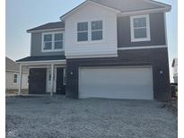 Charming two-story home showcasing a brick and vinyl exterior with an attached two car garage at 2209 Boxwood Dr, Greenfield, IN 46140