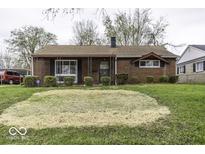 Quaint brick home featuring a tidy front yard and covered porch at 438 Park Dr, Greenwood, IN 46143