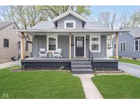 Charming gray home with a covered front porch, green lawn, and easy access walkway at 4719 Evanston Ave, Indianapolis, IN 46205