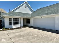 Charming white home featuring an attached two-car garage, and a well-kept lawn on a sunny day at 5129 W Preakness Ct, Muncie, IN 47304