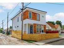 Modern two-story home with a white exterior, wood accents, and a stylish wood fence at 514 Spruce St, Indianapolis, IN 46203