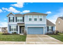 Charming two-story home featuring blue siding, black shutters, a concrete driveway, and an attached two-car garage at 5247 Crowley Pkwy, Whitestown, IN 46075