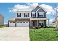 Charming two-story home featuring a three-car garage, brick accents, and a cozy front porch at 9916 Gallop Ln, Fishers, IN 46040