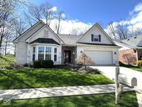 Charming home with a well-manicured lawn, beautiful bay window, and an attached two-car garage at 11602 Fairgreen Dr, Carmel, IN 46032