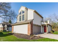 Charming two-story home with a red front door, attached garage and well-maintained lawn at 11674 Buttonwood Dr, Carmel, IN 46033