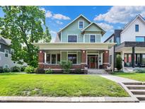 Charming two-story home with a lush green lawn and inviting front porch at 1826 N Alabama St, Indianapolis, IN 46202