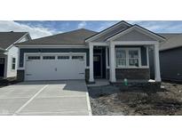 Charming single-story home featuring a two-car garage and a covered porch, complemented by a well-manicured lawn at 19565 Boulder Brook Ln, Westfield, IN 46074