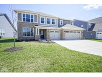 Attractive two-story home featuring a three-car garage, brick accents, and a large front lawn at 2237 S Copperstone Dr, New Palestine, IN 46163