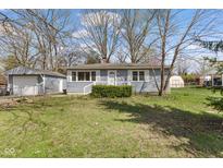 Charming single-story home featuring a well-maintained lawn and detached garage at 4159 Asbury St, Indianapolis, IN 46227
