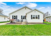 Charming home featuring a well-maintained lawn and a welcoming front porch with seating at 438 N 11Th Ave, Beech Grove, IN 46107