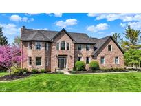 Beautiful two-story brick home with lush green lawn and meticulously maintained landscaping at 4932 Willow Ridge Ct, Zionsville, IN 46077