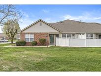 Charming brick home featuring a well-manicured lawn and a white picket fence, providing a cozy and inviting curb appeal at 5324 Rolling Meadow Blvd, Indianapolis, IN 46237