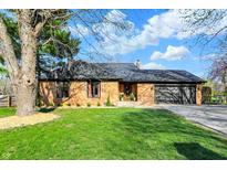 Charming brick home with an attached garage, mature tree, and beautifully landscaped front yard at 601 Ridge Rd, Greenwood, IN 46142