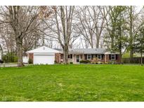 Charming single-story home with a brick facade, attached garage and a lush, green front lawn at 6130 Forest View Dr, Indianapolis, IN 46228