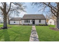Charming single-story home with a well-manicured lawn and walkway leading to the front door at 6300 N Keystone Ave, Indianapolis, IN 46220