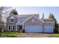 Charming two-story home with brick and light blue siding, a well-manicured lawn, and an attached two-car garage at 6967 Bluffridge Way, Indianapolis, IN 46278