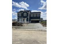 A two-story home with a dark exterior, shuttered windows and a concrete driveway under a partly cloudy sky at 7167 Finley Creek Dr, Whitestown, IN 46075