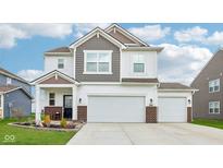 Two-story home featuring a 2-car garage, landscaped front yard, and a welcoming porch at 8663 Kellner St, Pendleton, IN 46064