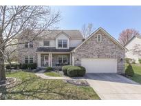 Charming two-story brick home with a well-manicured lawn and attached two-car garage at 9760 Logan Ln, Fishers, IN 46037