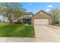 Charming two-story home with brick accents, a well-manicured lawn, and a bright blue front door at 1014 Sugar Maple Dr, Greenwood, IN 46143