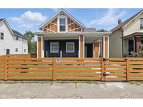 Charming two-story home features a delightful front yard enclosed with a wooden fence at 1321 Union St, Indianapolis, IN 46225