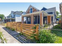 Charming two-story home with a new wooden fence, manicured lawn, and colorful exterior paint at 1321 Union St, Indianapolis, IN 46225
