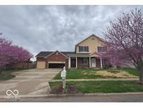 Charming two-story home with a well-maintained lawn, blossoming trees and attached two-car garage at 1647 Danaher St, Indianapolis, IN 46217