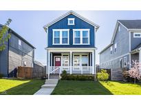Charming two-story home with a beautiful blue exterior and well-manicured lawn at 2023 Alvord St, Indianapolis, IN 46202