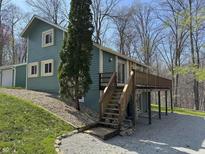 Charming two story home with elevated deck and staircase surrounded by lush green landscaping at 3764 E Glenwood Dr, Martinsville, IN 46151