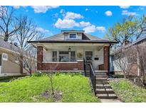 Charming home featuring brick accents, a welcoming porch, and a well-manicured lawn at 52 N Oakland Ave, Indianapolis, IN 46201