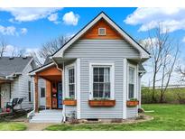 Charming home with gray siding, flower-filled window boxes and striking architectural details at 922 Cottage Ave, Indianapolis, IN 46203