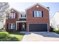 Charming two-story brick home featuring a well-maintained lawn, black shutters, and attached two-car garage at 10105 Yosemite Ln, Indianapolis, IN 46234